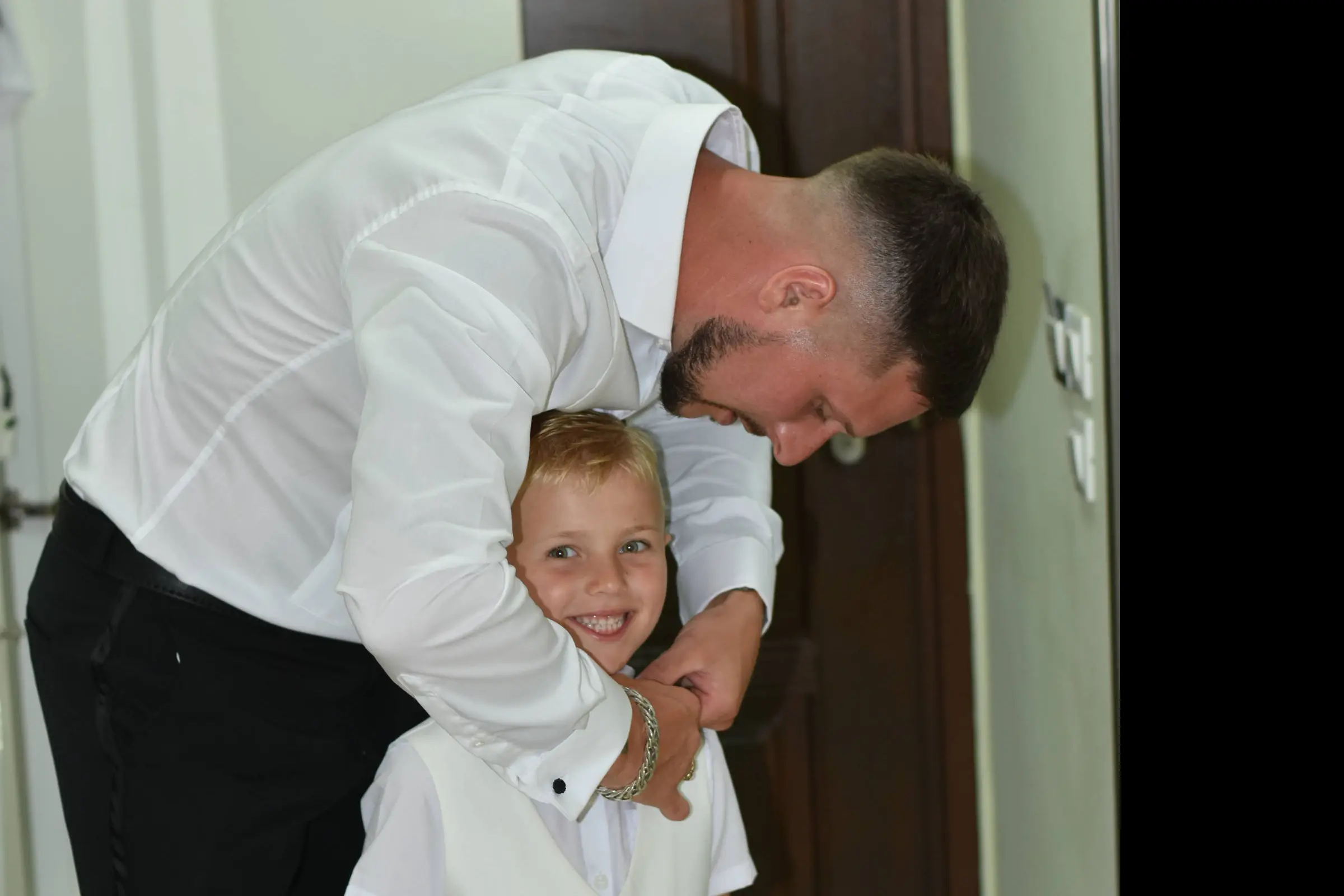 fater sorting his son shirt button at his wedding