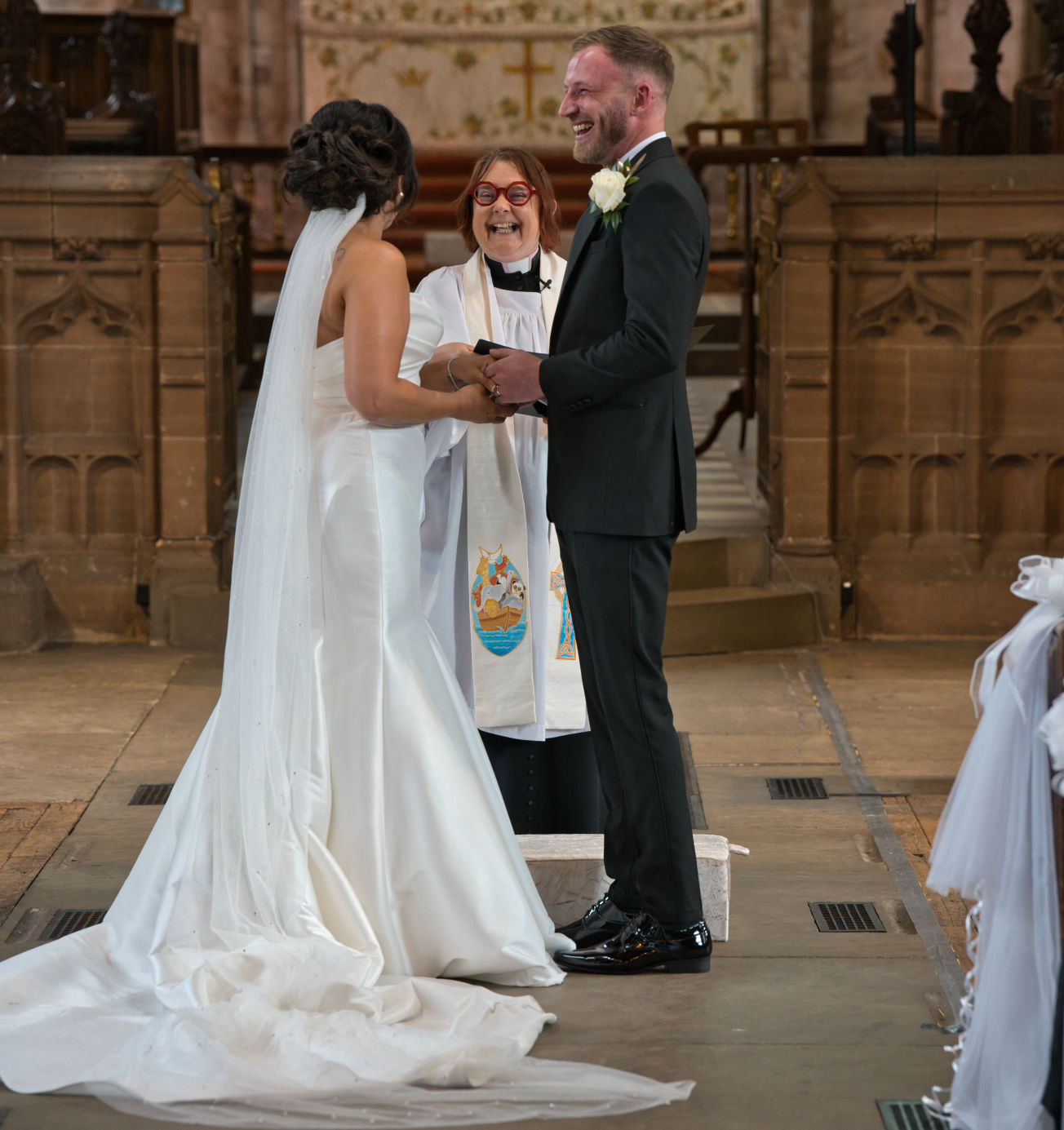 The bride and groom in Vicar enjoy a funny moment at the wedding at St George's Church, London Road, Stockport